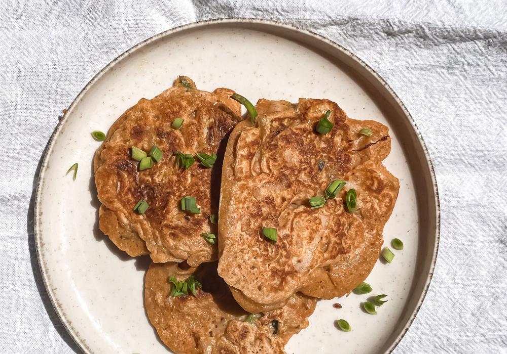 panqueques de kimchi en una plato blanco sobre mantel blanco