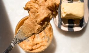 manteca de miso en un cuchillo de untar y manteca en una mantequera rayada