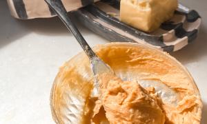manteca de miso en un cuchillo de untar y manteca en una mantequera rayada
