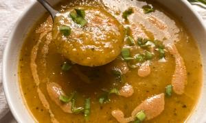 Sopa de miso y verduras con cebollino sobre mantel blanco
