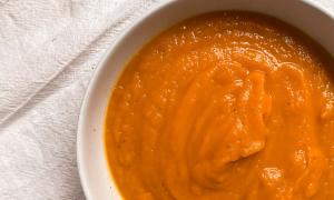 sopa de calabaza y zanahoria sobre mantel blanco