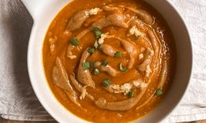 Sopa de miso con calabaza, zanahoria y cúrcuma en bowl blanco sobre tabla de madera